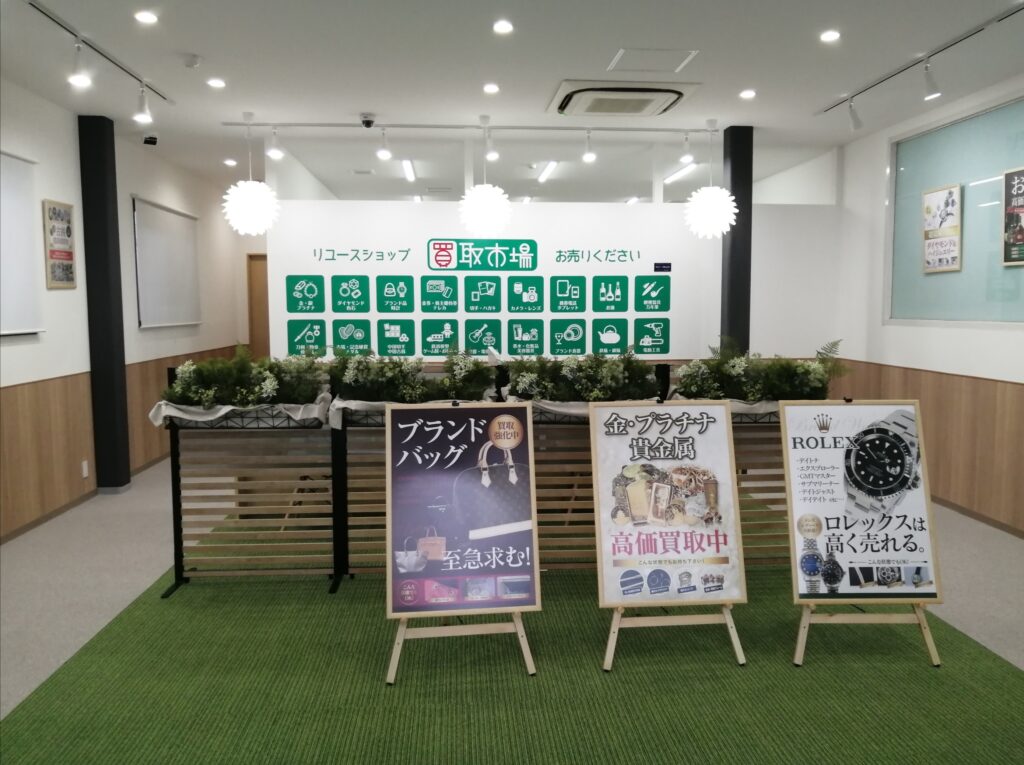 買取市場 鎌取駅前店の店内。買取品目のアイコンが並ぶ壁と、ブランドバッグ・金プラチナ・ロレックスの買取案内