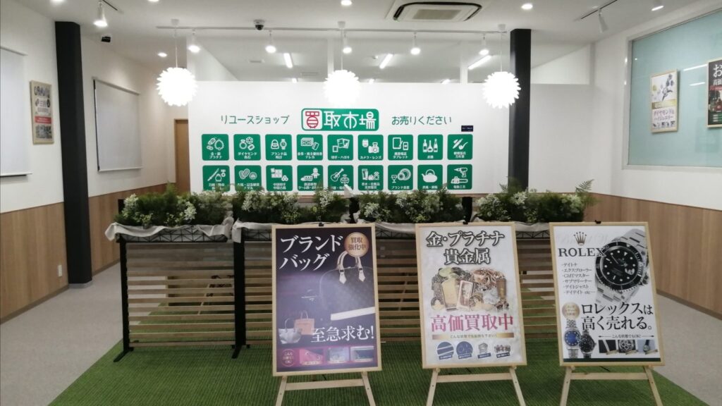 買取市場 鎌取駅前店の店内。買取品目のアイコンが並ぶ壁と、ブランドバッグ・金プラチナ・ロレックスの買取案内